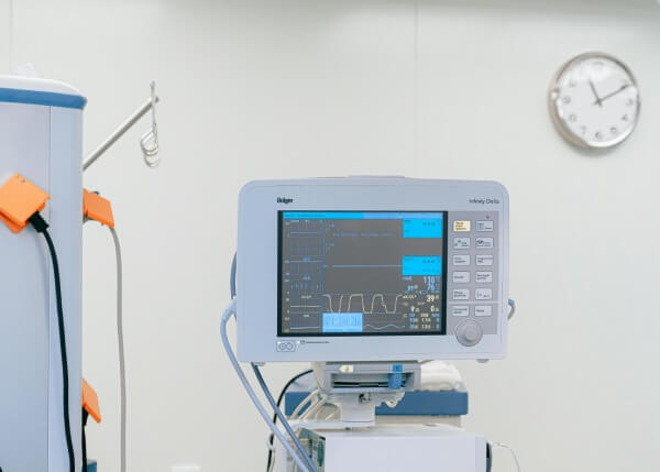 A machine in a hospital with a clock on the wall