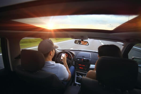 A teenager texting and driving.