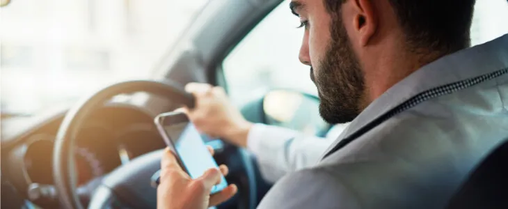 Man looking at his phone while driving