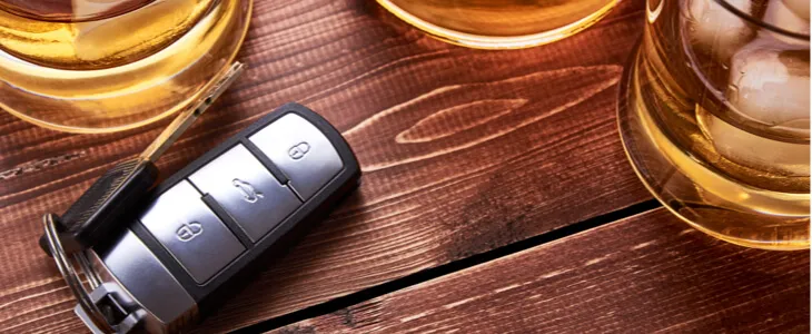 Car keys on bar next to alcoholic drinks