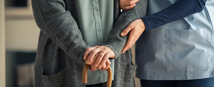 nurse helping an elderly person walk